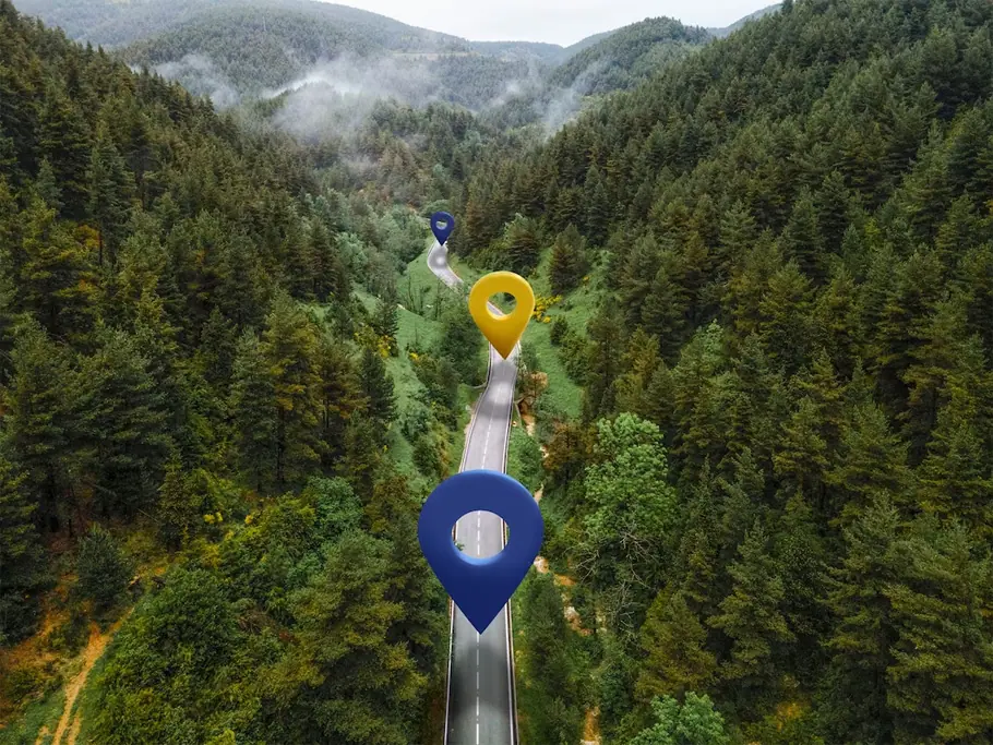 Map pins on forest mountain road